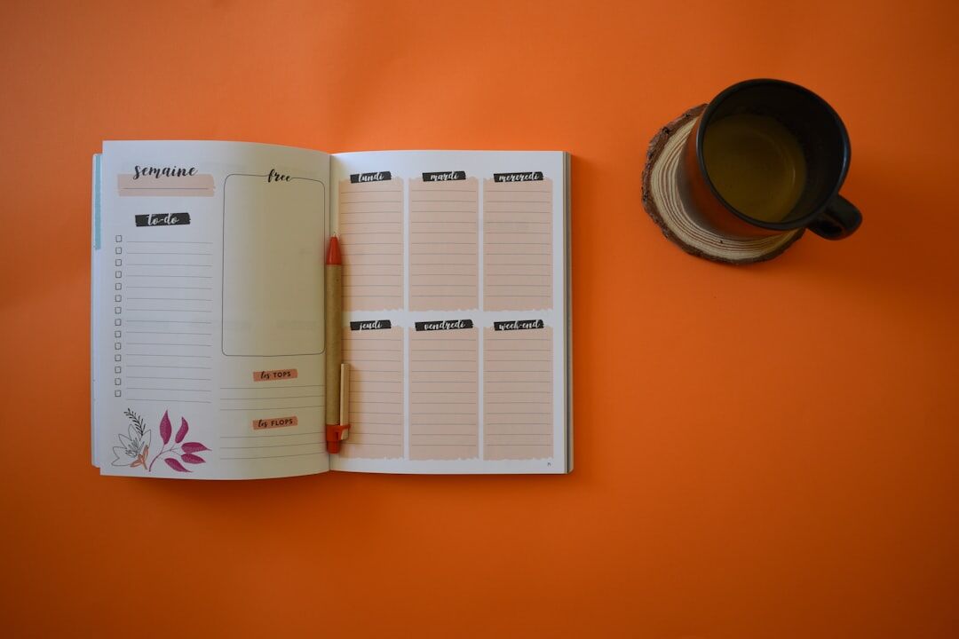 Open notebook and coffee cup on a desk with contact sheet prints