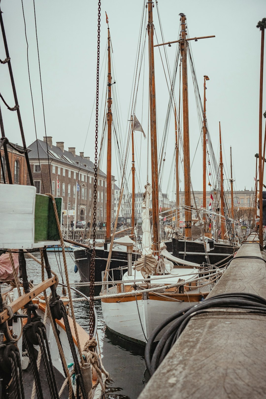 Elderly Danish fisherman mending nets on a harbor pier
