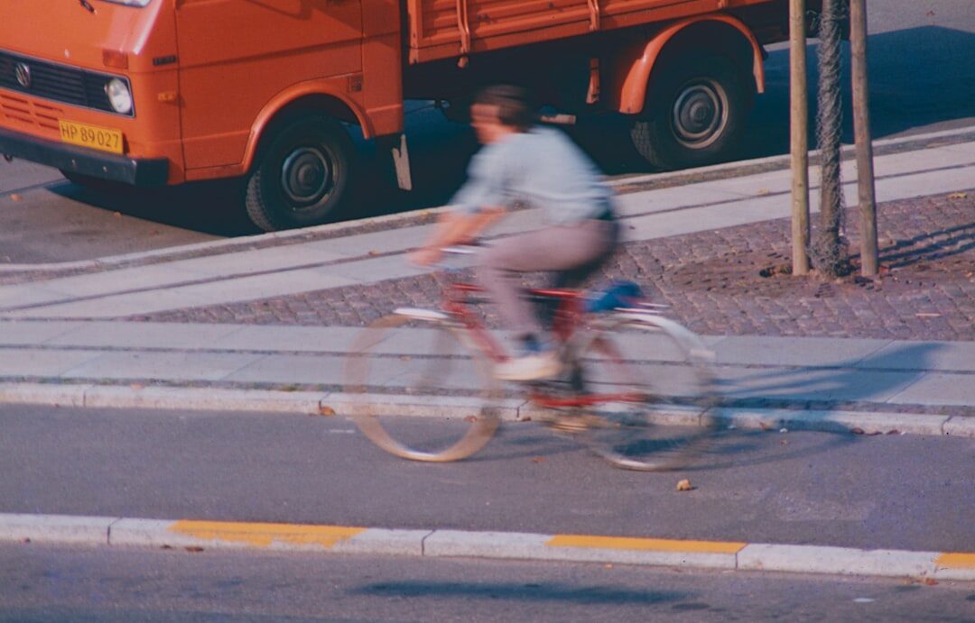 Danish teenager riding a bicycle through a cobbled street